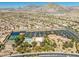 Scenic aerial view of a community featuring amenities, including tennis courts, bocce ball, pool, and clubhouse with desert landscape at 10413 Marymont Pl, Las Vegas, NV 89134