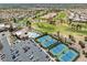Aerial view: community clubhouse, pool, tennis courts next to a golf course and neighborhood under a clear sky at 10413 Marymont Pl, Las Vegas, NV 89134