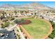 Scenic aerial view of the baseball field in a residential area, framed by lush trees and rolling mountains at 10413 Marymont Pl, Las Vegas, NV 89134