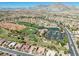 Aerial view of golf course in a residential neighborhood featuring a pond and green grass at 10413 Marymont Pl, Las Vegas, NV 89134