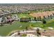 Aerial view of a community golf course and pond with nearby parking at 10413 Marymont Pl, Las Vegas, NV 89134
