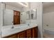 Bathroom featuring double sinks, wood cabinets, and a large mirror at 1054 Broomfield Dr, Henderson, NV 89074