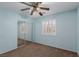 This bedroom has carpeted floors, light blue walls, and a ceiling fan with a light at 1054 Broomfield Dr, Henderson, NV 89074