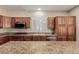 Large kitchen with granite countertops, wood cabinets, and stainless steel appliances at 1054 Broomfield Dr, Henderson, NV 89074