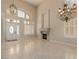 Living room with high ceilings, fireplace, neutral paint, tile floors, and a front door with sidelights at 1054 Broomfield Dr, Henderson, NV 89074
