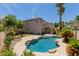 View of the pool surrounded by lush greenery and the rear of the house at 1054 Broomfield Dr, Henderson, NV 89074