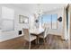 Bright dining room with a modern light fixture, a large window, and wood flooring at 10863 Gardenova Ave, Las Vegas, NV 89166