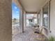 Inviting covered front porch with comfortable seating and decorative stone columns at 10863 Gardenova Ave, Las Vegas, NV 89166