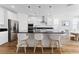 Modern kitchen boasts stainless steel appliances, white cabinetry, granite countertops and a center island at 10863 Gardenova Ave, Las Vegas, NV 89166