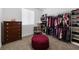 Spacious walk-in closet featuring ample shelving and hanging storage, with a plush ottoman and dresser at 10863 Gardenova Ave, Las Vegas, NV 89166