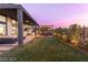 Spacious backyard featuring a well-manicured lawn, modern patio, and outdoor dining area at 11015 Sanctuary Cove Ct, Las Vegas, NV 89135