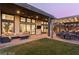 Expansive backyard with covered patio, outdoor seating, and a view of the kitchen through large windows at 11015 Sanctuary Cove Ct, Las Vegas, NV 89135
