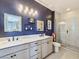 Stylish bathroom features a double sink vanity, framed mirrors and a sleek glass enclosed shower at 11739 Emerald Lake Ave, Las Vegas, NV 89138