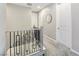 Hallway with carpet, black iron railing, and a decorative mirror near a bedroom entrance at 11739 Emerald Lake Ave, Las Vegas, NV 89138