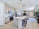 Modern kitchen with an island, stainless steel appliances, pendant lighting and adjacent living room at 11739 Emerald Lake Ave, Las Vegas, NV 89138