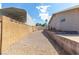 Backyard view features desert rock, neutral brick wall, concrete patio and shed at 120 W Highland Dr, Henderson, NV 89015