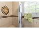 Shower area featuring stylish tile design, shower curtain, and glass block window at 120 W Highland Dr, Henderson, NV 89015