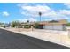 Street view of home with two car garage, desert landscaping, and mature palm tree at 120 W Highland Dr, Henderson, NV 89015