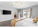 Bright bedroom features a TV, slider door, and a stylish light fixture at 120 W Highland Dr, Henderson, NV 89015