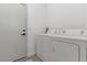 Clean laundry room with a washer, dryer, and a door, offering convenience and functionality at 1310 Ripplestone Ave, North Las Vegas, NV 89081
