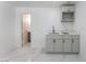 A minimalist kitchen featuring modern gray cabinets, a stainless steel sink, and marble floors that add a touch of elegance at 1313 Purple Sage Ave, Las Vegas, NV 89108