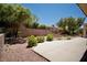 Backyard showing desert landscaping, greenery, a paved area, and mature trees at 1830 Lake Wales St, Henderson, NV 89052