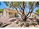 Backyard view with a covered patio, a table set, mature trees, and a gravel landscape at 1830 Lake Wales St, Henderson, NV 89052