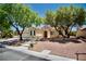 Inviting single-story home with desert landscaping, concrete steps, and mature shade trees at 1830 Lake Wales St, Henderson, NV 89052