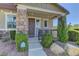 Inviting front porch with stone supports and a cozy seating area, perfect for relaxing outdoors at 1904 Via Firenze, Henderson, NV 89044