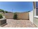 Enclosed brick patio with a view of the backyard fence and some greenery at 1904 Via Firenze, Henderson, NV 89044