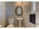 Charming powder room with pedestal sink, oval mirror, and neutral decor at 1904 Via Firenze, Henderson, NV 89044