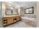 Elegant bathroom featuring a soaking tub, dual sinks, a large mirror, and marble flooring at 2000 N Fashion Show Dr # 3000, Las Vegas, NV 89109