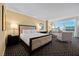 Bright bedroom featuring a king-sized bed, sitting area with city views, and patterned carpeting at 2000 N Fashion Show Dr # 3000, Las Vegas, NV 89109