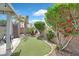 Charming backyard with a putting green, mature landscaping, and a covered seating area at 2011 Mountain Sunset Ave, North Las Vegas, NV 89031