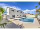 This backyard features a refreshing pool, desert landscaping, and a white two-story home at 2611 Siesta Ave, Las Vegas, NV 89121