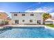 Backyard pool area featuring a refreshing pool, concrete patio, two-story home, and manicured yard under a bright blue sky at 2611 Siesta Ave, Las Vegas, NV 89121