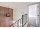 Hallway featuring wood accent wall, metal railing, and modern light fixture leading to a bedroom with carpet at 2611 Siesta Ave, Las Vegas, NV 89121