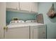 Laundry room showcasing a white washer and dryer set, and overhead storage cabinets at 2716 Orchid Moon Ct, North Las Vegas, NV 89031