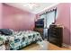 A cozy bedroom with lilac walls, featuring a bed, dresser, and a mounted TV for relaxation at 3108 Sentimental Ct, North Las Vegas, NV 89031