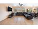 Spacious living room with tile flooring, a ceiling fan, and a comfortable dark leather sectional sofa at 3108 Sentimental Ct, North Las Vegas, NV 89031