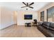 Bright living room with tile flooring, a ceiling fan, and a comfortable dark leather sofa at 3108 Sentimental Ct, North Las Vegas, NV 89031