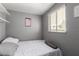 Cozy bedroom with natural light from the window and minimalistic decor on the gray walls at 3158 Brockington Dr, Las Vegas, NV 89120