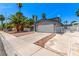Exterior view with ample driveway space, gated fence, and mature palm trees at 3158 Brockington Dr, Las Vegas, NV 89120