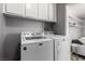 Convenient laundry area with modern washer and dryer units and overhead cabinet space at 3158 Brockington Dr, Las Vegas, NV 89120