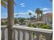 Balcony view overlooking a tranquil street lined with mature palm trees and stunning architecture at 3372 Westwind Rd, Las Vegas, NV 89146