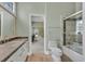 Bright bathroom featuring a tub/shower combo with marble tile and a sink with granite counters at 3372 Westwind Rd, Las Vegas, NV 89146