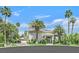 Stately stucco home featuring lush landscaping, a circular driveway, and ample palm trees at 3372 Westwind Rd, Las Vegas, NV 89146