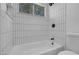 Bathtub with tiled walls with shower fixture and a window for natural lighting at 363 El Pico Dr, Henderson, NV 89014