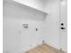 A minimalist laundry room with a floating shelf, hook-up and white door at 363 El Pico Dr, Henderson, NV 89014