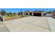 Spacious driveway with a brick wall and desert landscaping leading to an attached garage at 3917 Leon Ave, Las Vegas, NV 89130
